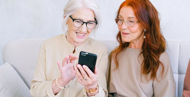 cheerful senior women shopping online on smartphone