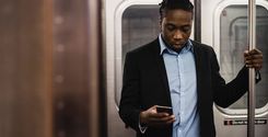 black office employee using smartphone on train