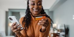 woman smiling at phone and credit card