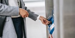 woman swiping debit card in bank atm machine