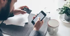 man looking up financial information on smartphone