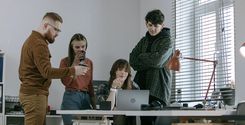 employees having a discussion around computer